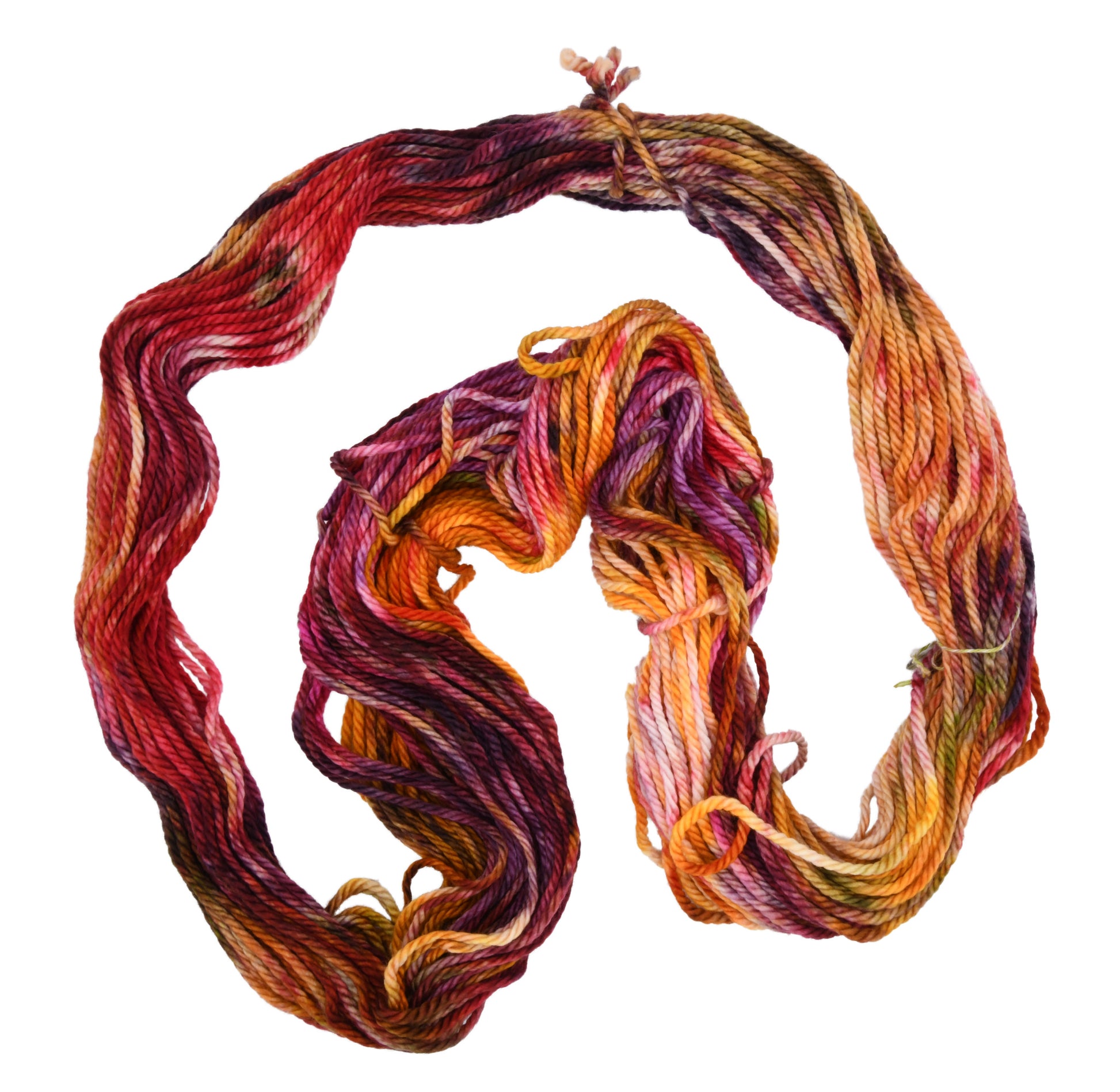 An unfolded hank of Reykjavik Hot Spot hand-dyed bulky weight yarn showing a lively mix of red, orange, salmon pink, sage green, and deep aubergine, perfect for vibrant handmade creations.