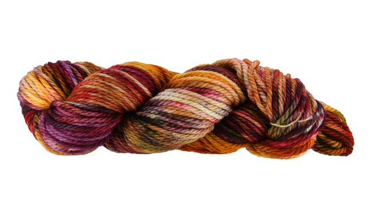 A twisted hank of Reykjavik Hot Spot hand-dyed bulky weight yarn showing a lively mix of red, orange, salmon pink, sage green, and deep aubergine, perfect for vibrant handmade creations.