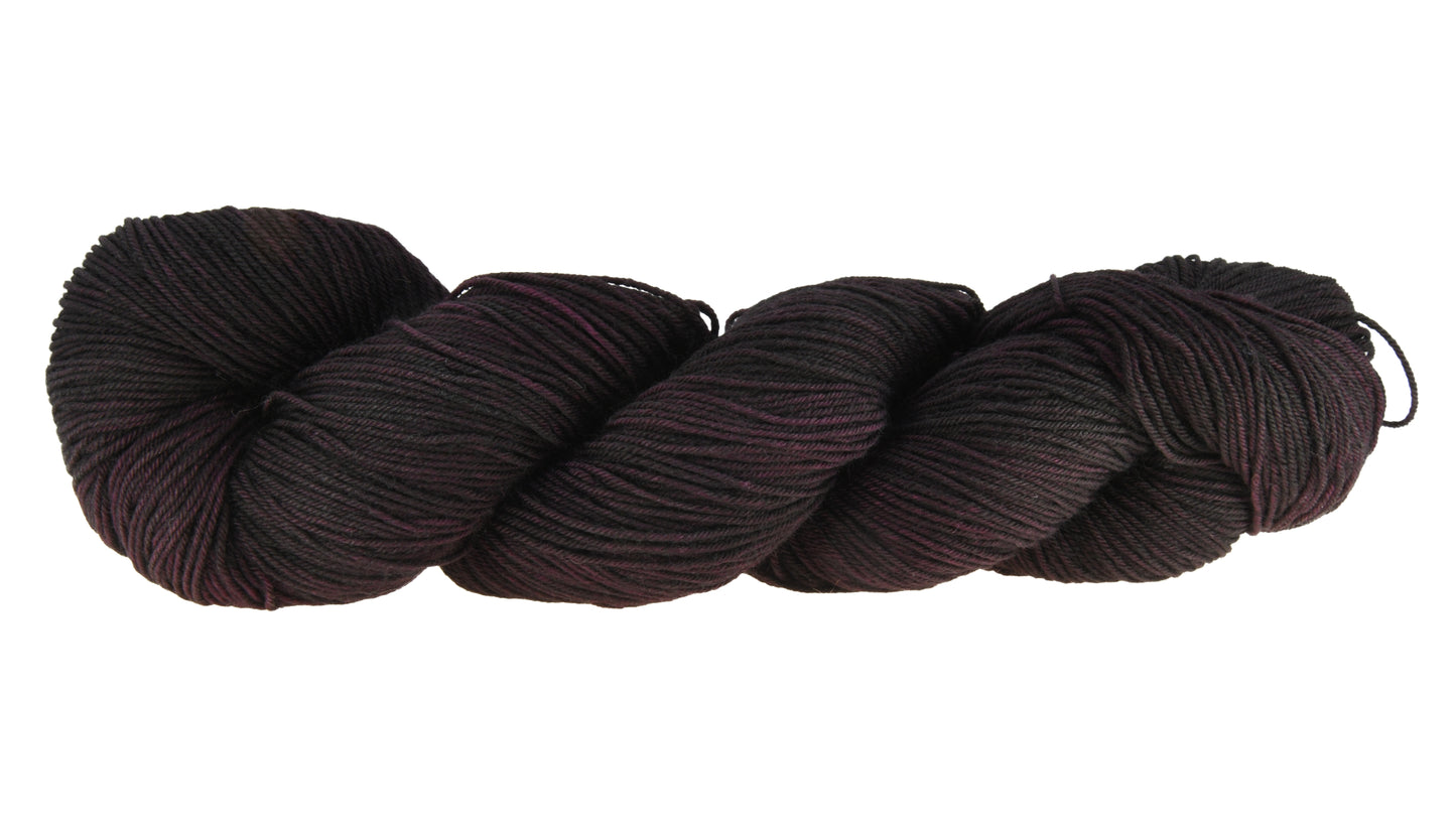 Barn Yarn twisted skein of Shiraz fingering weight hand-dyed yarn in a deep, dark burgundy, ideal for knitting and crochet projects needing rich, wine-inspired color.