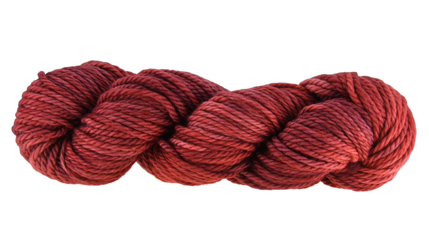 Wine Rose hand-dyed bulky weight yarn in a deep rose shade, shown in a twisted hank to emphasize its tonal richness and chunky texture.