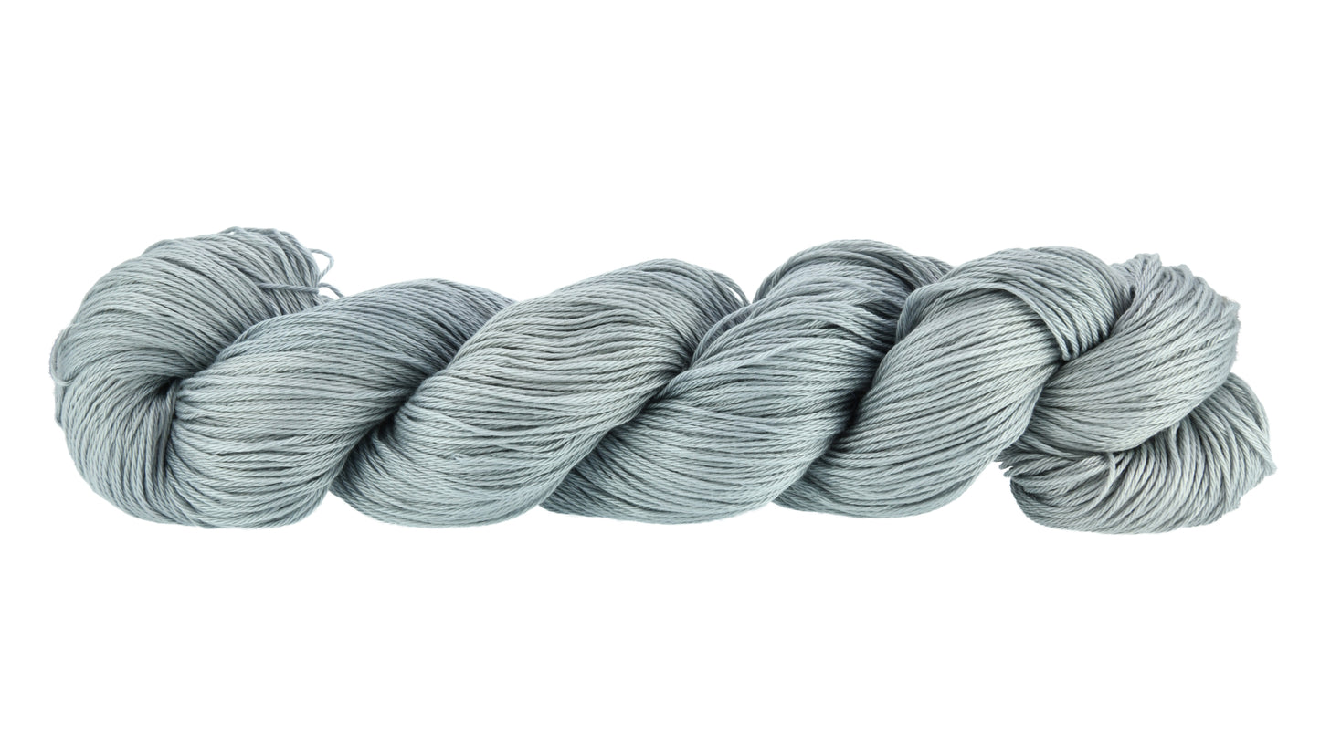 Barn Yarn Hand-dyed fingering weight yarn in colorway I Slate a Dragon!  — 100% recycled cotton in a soft light gray tone, twisted into a hank to highlight its smooth 4-ply construction and subtle luster.