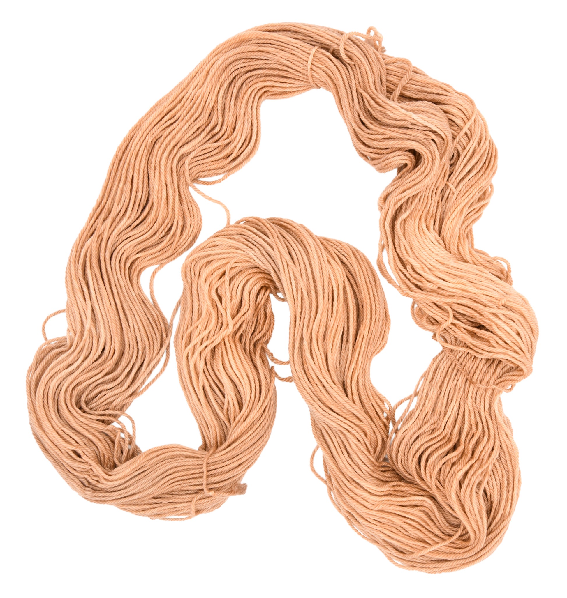 An unfolded skein of Barn Yarn hand-dyed DK weight yarn in colorway Pink Sand, a soft blush pink with sandy undertones, perfect for knitting and crochet projects.