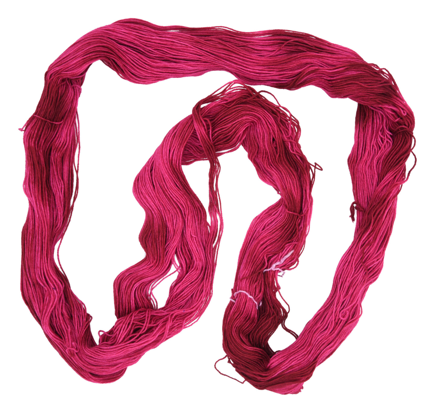 An unfolded hank of fingering weight hand-dyed yarn in colorway Pomegranate featuring layered bright and dark saturated pink tones, ideal for vibrant handmade creations.