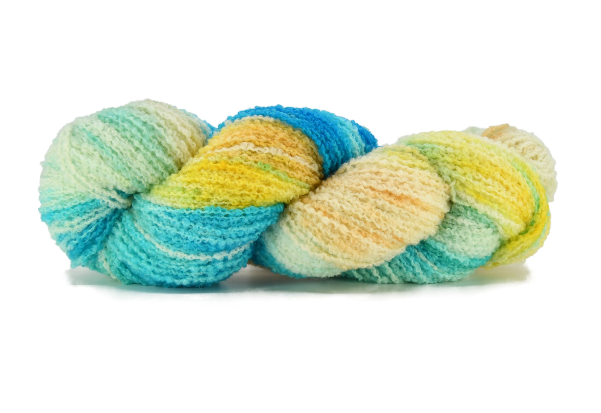 A twisted skein of Barn Yarn hand-dyed boucle DK weight yarn in colorway Down by the Seaside with breezy blues, sandy neutrals, and sea-glass greens, perfect  knitting and crochet.