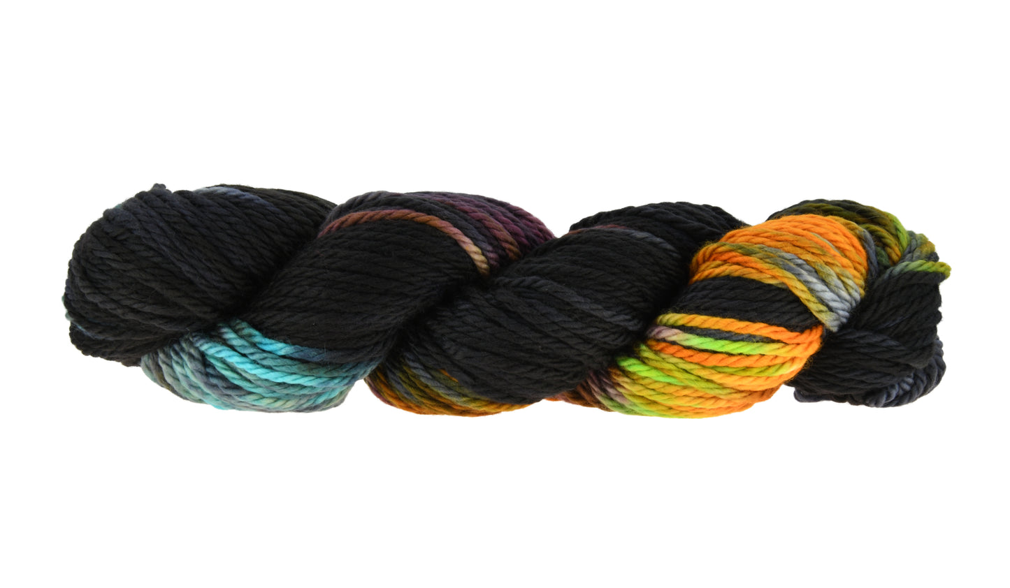 A twisted skein of Barn Yarn hand-dyed bulky weight yarn in colorway Imperial Pumpkin - a black base layered with pumpkin orange, plum, blue, gray, green, and warm browns. Perfect for knitting and crochet projects.