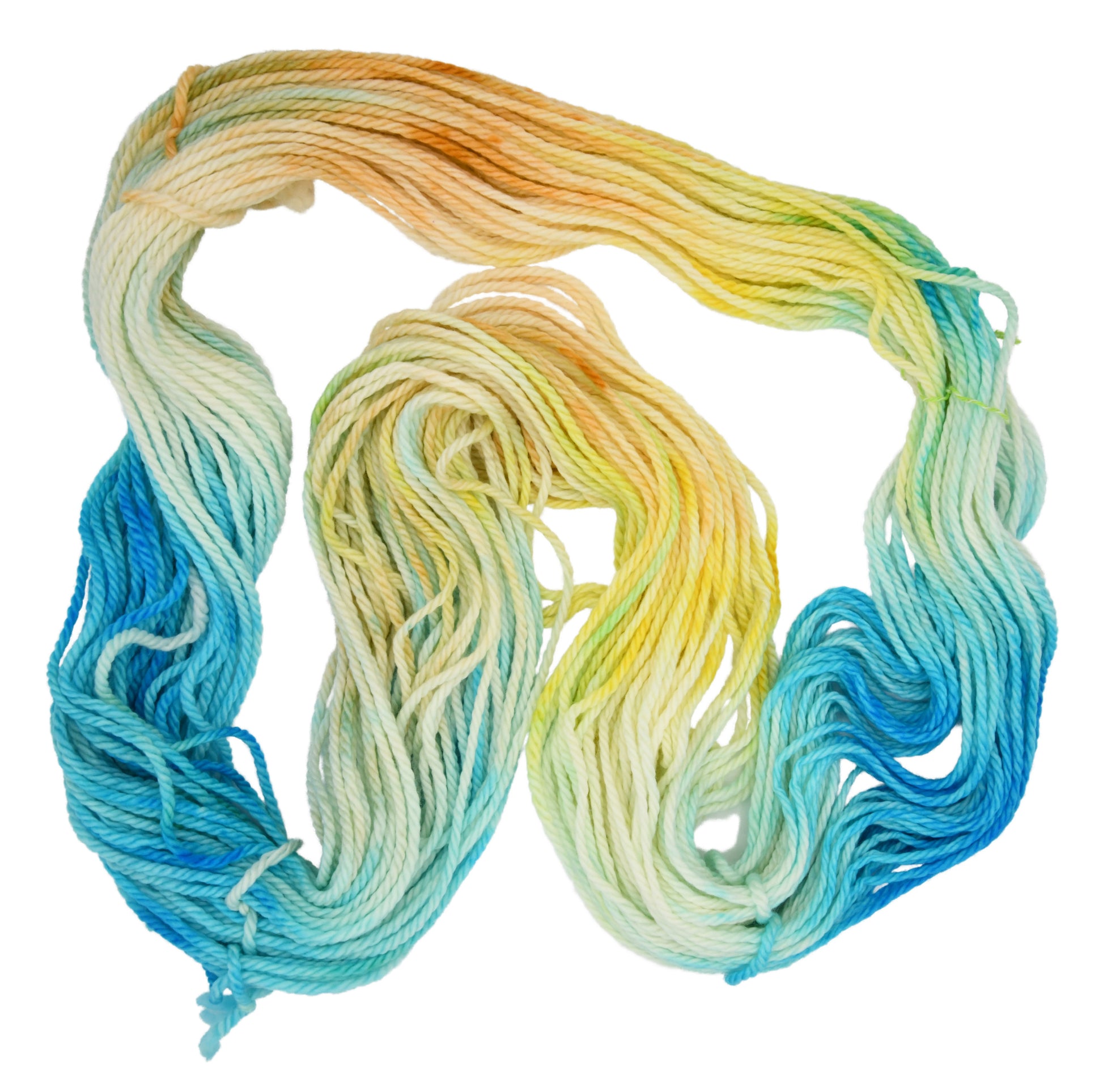 An unfolded skein of Barn Yarn hand-dyed bulky weight yarn in colorway Down by the Seaside with breezy blues, sandy neutrals, and sea-glass greens, perfect  knitting and crochet.