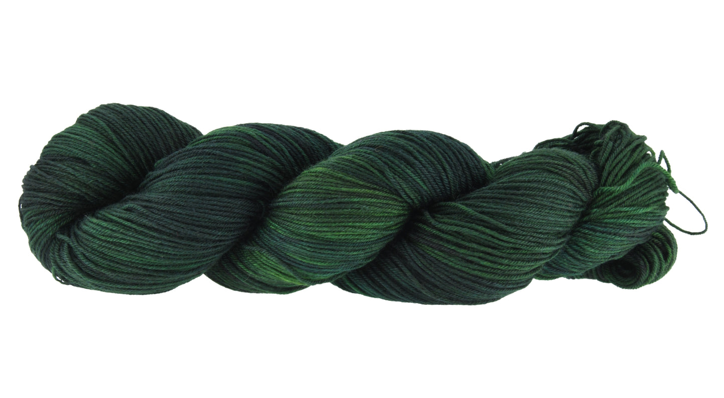 A twisted skein of Barn Yarn hand-dyed fingering weight yarn in colorway Holly Leaves, a classic evergreen with deep, saturated tones perfect for all knit and crochet projects.
