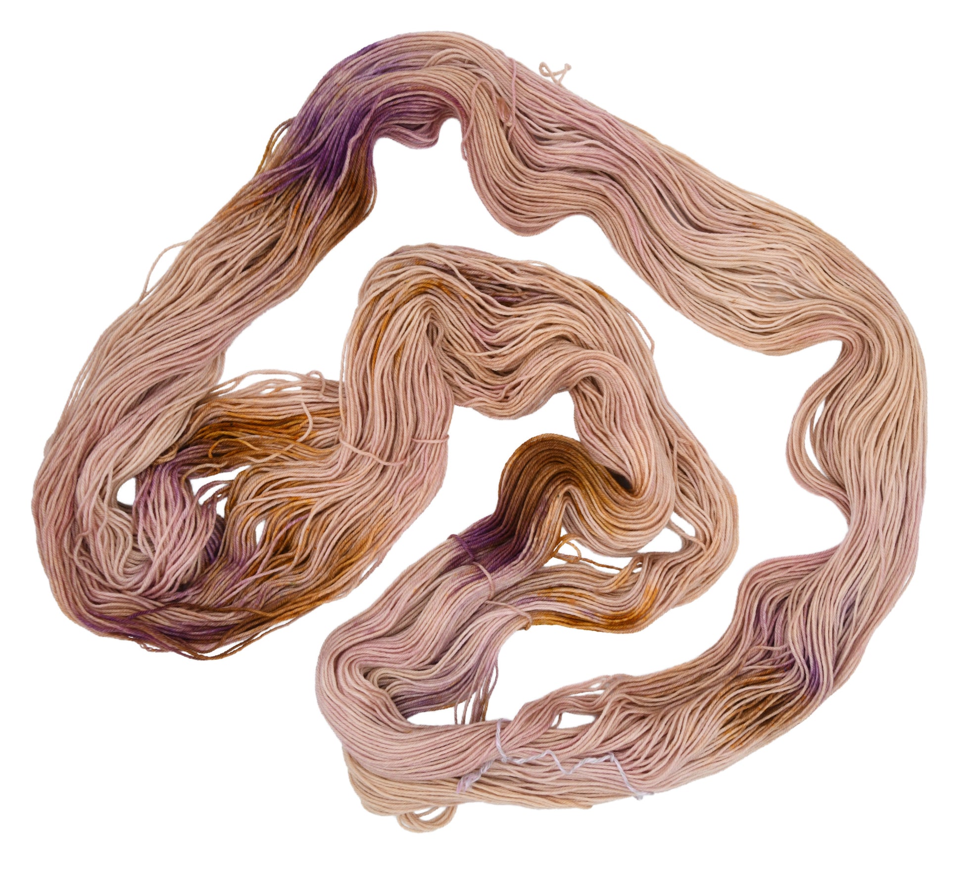 An unfolded skein of Barn Yarn hand-dyed fingering weight yarn in colorway Nougat, a light pink, toffee, and purple combination, perfect for knitting and crochet projects.