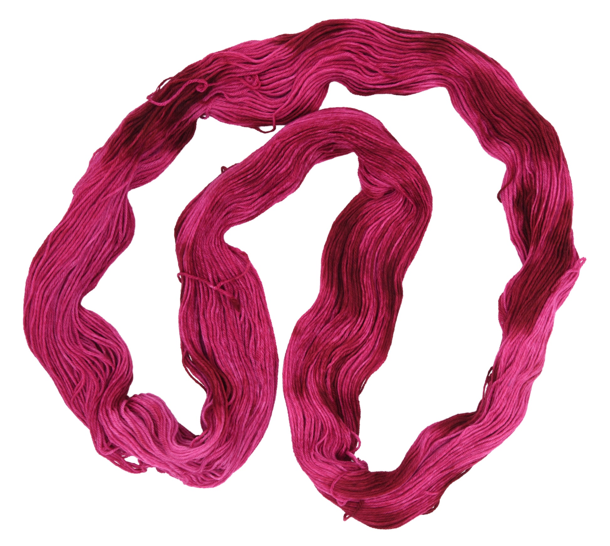 An unfolded hank of merino-cashmere-nylon-blend fingering weight hand-dyed yarn in colorway Pomegranate featuring layered bright and dark saturated pink tones, ideal for vibrant handmade creations.