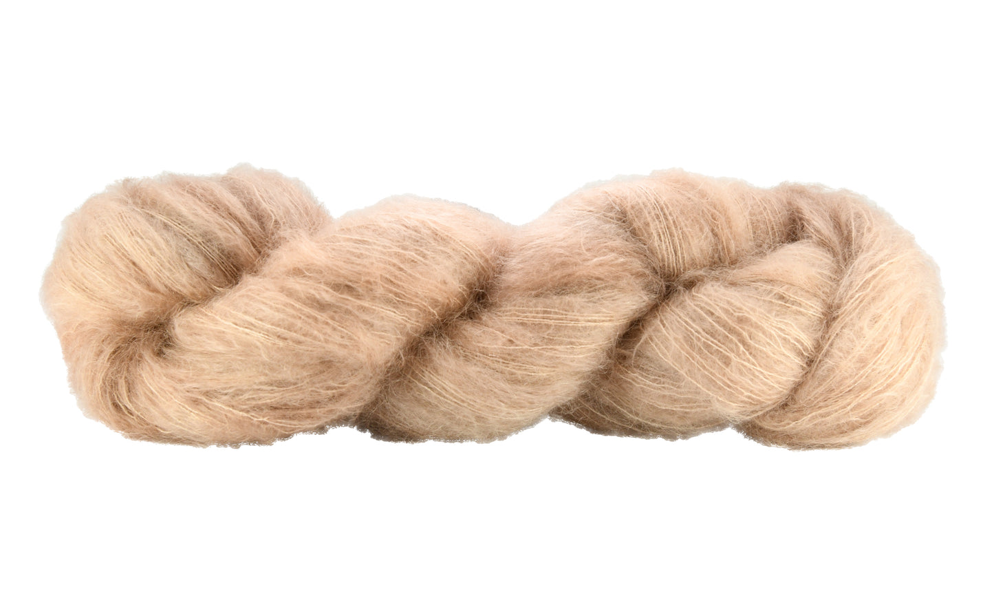 A twisted skein of Barn Yarn hand-dyed mohair yarn in colorway Pink Sand, a soft blush pink with sandy undertones, perfect for knitting and crochet projects.