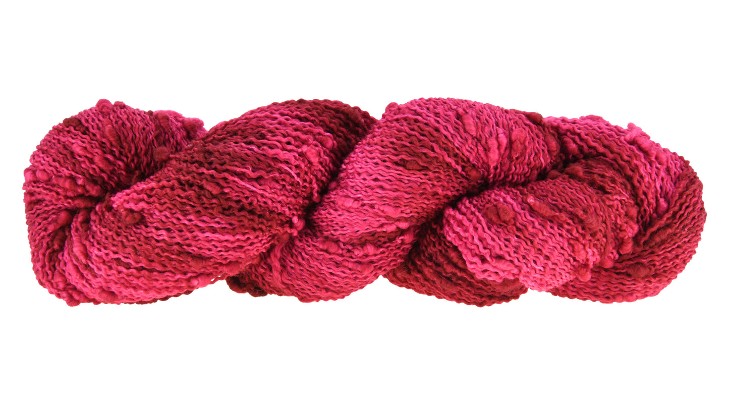 A twisted hank of slub hand-dyed yarn in colorway Pomegranate featuring layered bright and dark saturated pink tones, ideal for vibrant handmade creations.