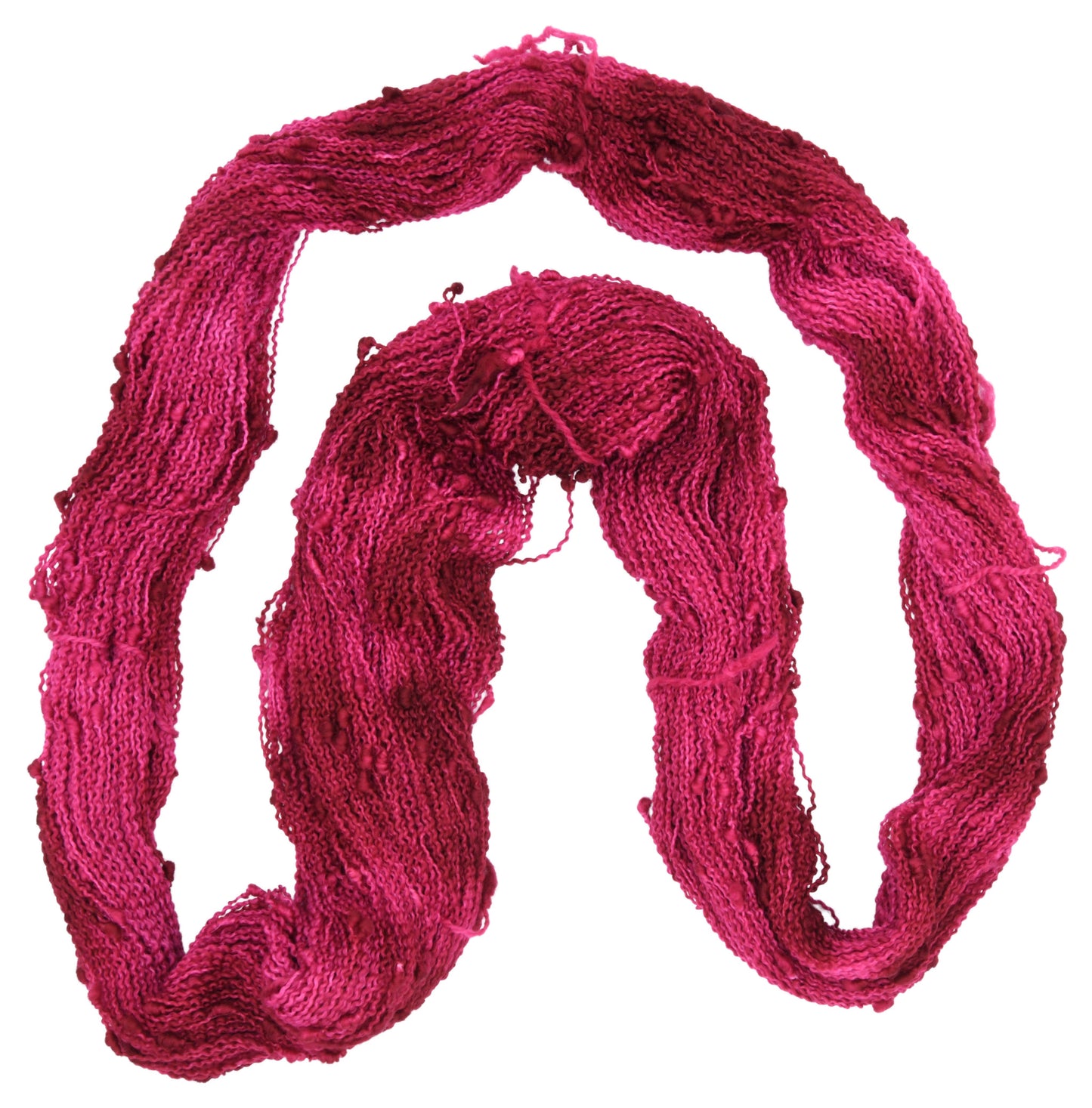 An unfolded hank of slub hand-dyed yarn in colorway Pomegranate featuring layered bright and dark saturated pink tones, ideal for vibrant handmade creations.