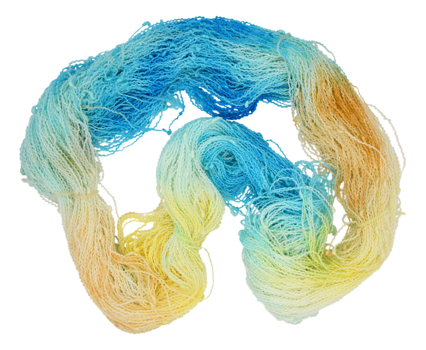 An unfolded skein of Barn Yarn hand-dyed slub yarn in colorway Down by the Seaside with breezy blues, sandy neutrals, and sea-glass greens, perfect  knitting and crochet.