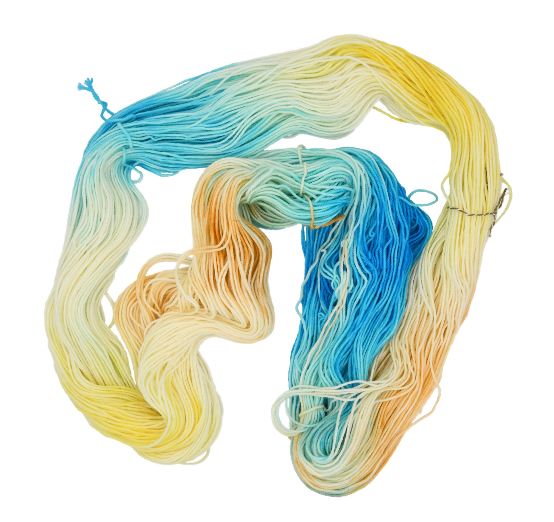 An unfolded skein of Barn Yarn hand-dyed sport weight yarn in colorway Down by the Seaside with breezy blues, sandy neutrals, and sea-glass greens, perfect  knitting and crochet.