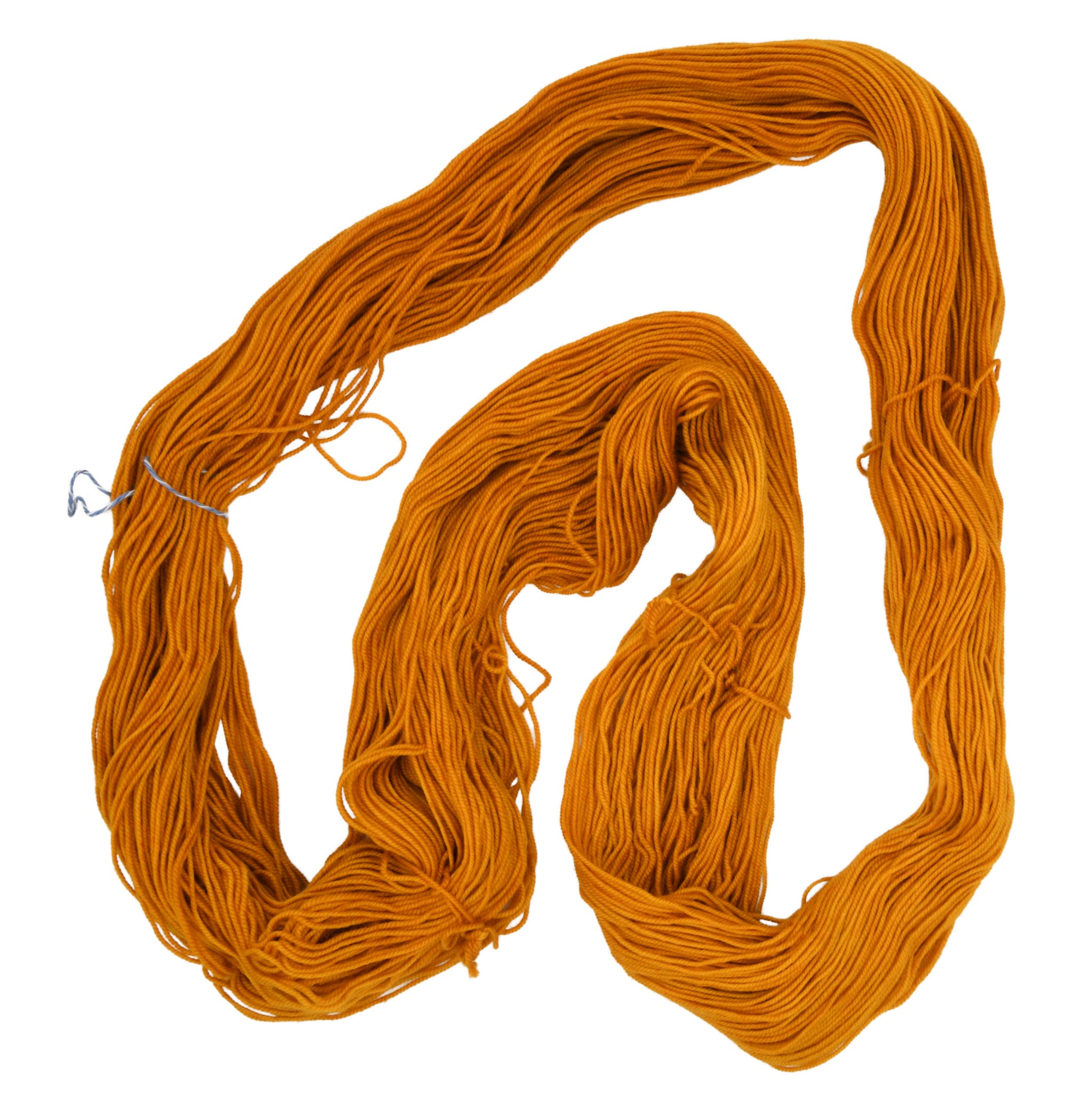 An unfolded skein of Barn Yarn hand-dyed sport weight yarn in colorway Golden Era, a radiant golden yellow shade, perfect for warm and luxurious knitting and crochet projects.