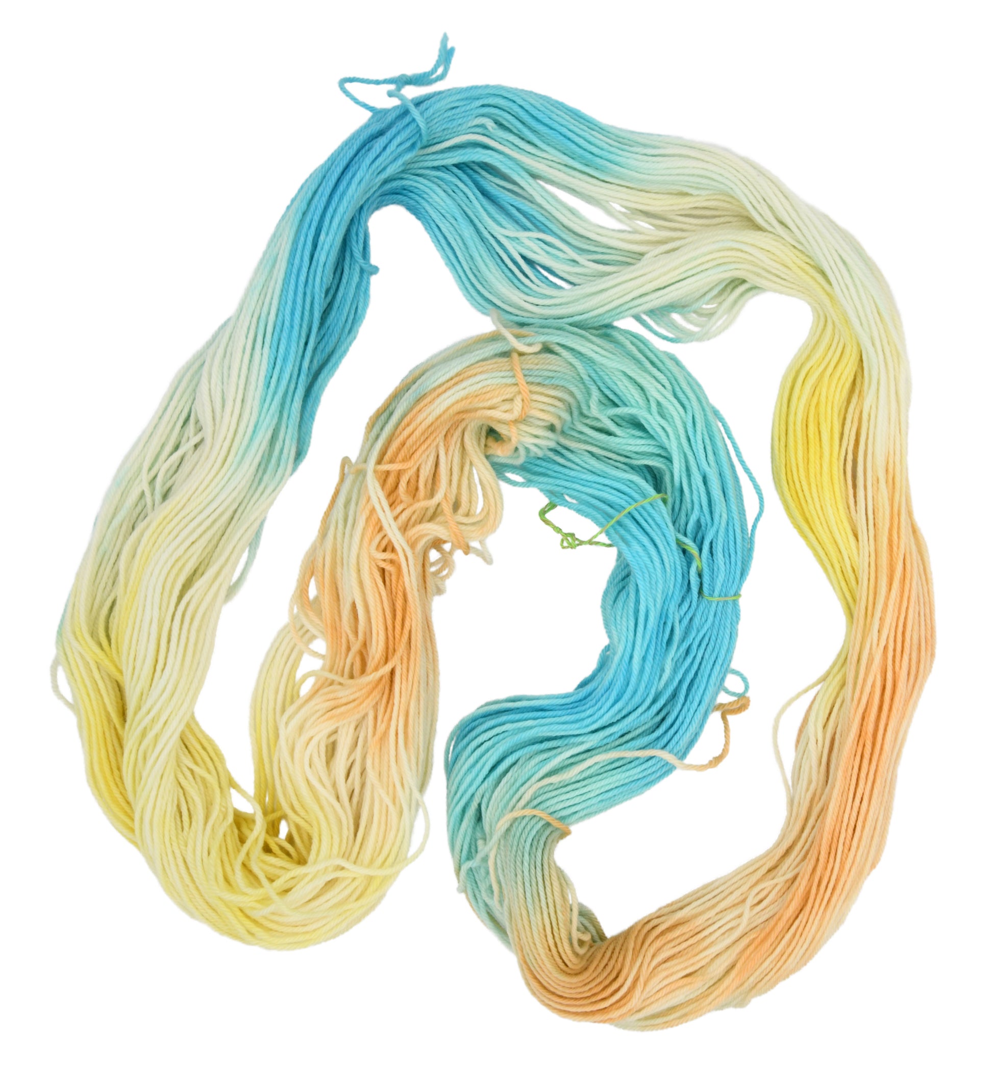 An unfolded skein of Barn Yarn hand-dyed worsted weight yarn in colorway Down by the Seaside with breezy blues, sandy neutrals, and sea-glass greens, perfect  knitting and crochet.