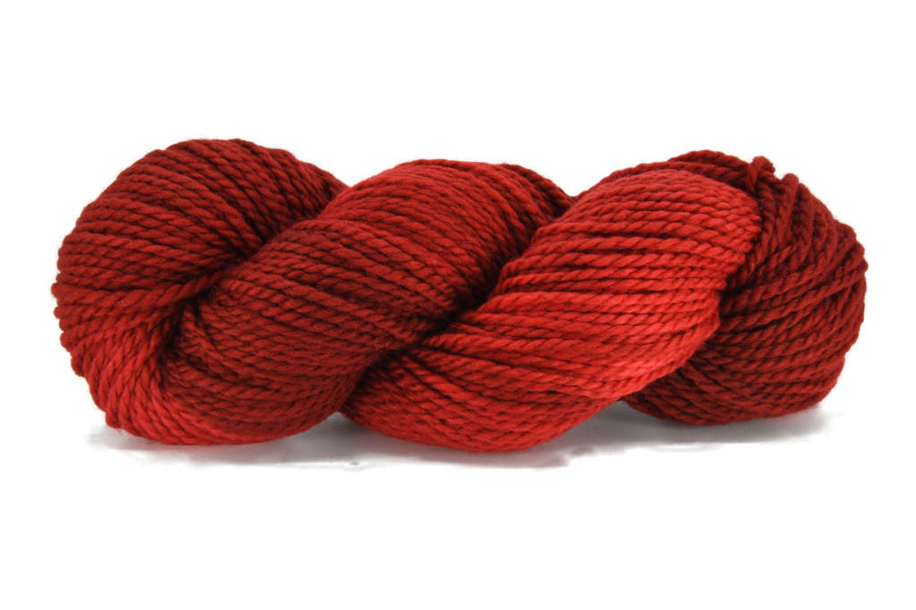 A twisted skein of Barn Yarn hand-dyed bulky weight yarn in colorway Chili Pepper, a vibrant, spicy red, perfect for bold and cozy knitting and crochet projects.