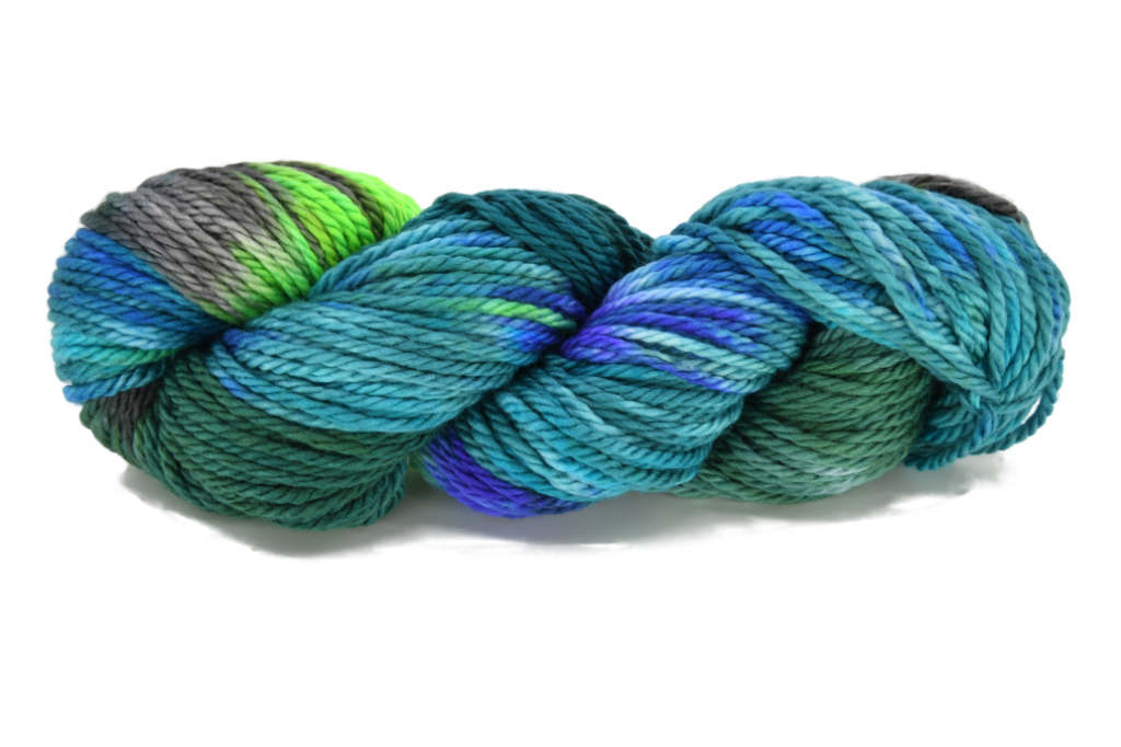 A twisted skein of Barn Yarn hand-dyed bulky weight yarn in colorway Play the Peacock -vibrant teal, emerald green, rich blue inspired by the colors of a peacock’s feathers.